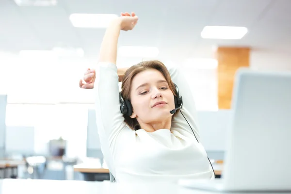 Rilassato bella donna seduta e che si estende sul posto di lavoro — Foto Stock