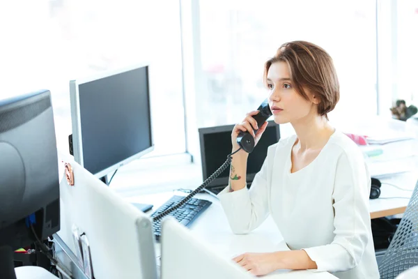 Серйозна бізнес-леді розмовляє по телефону — стокове фото