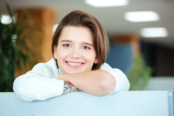 オフィスで笑みを浮かべて魅力的な陽気な若い女性 — ストック写真