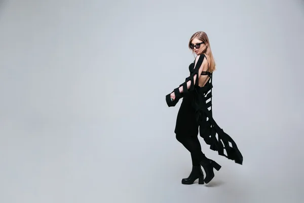 Weibliches Model posiert in modischem Lappen und Sonnenbrille — Stockfoto