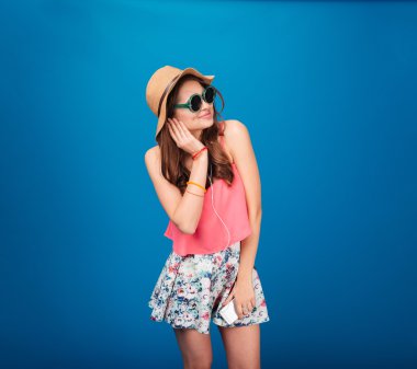 Mutlu güzel kadın listeting müzik için kulaklık kullanarak smartphone üzerinden