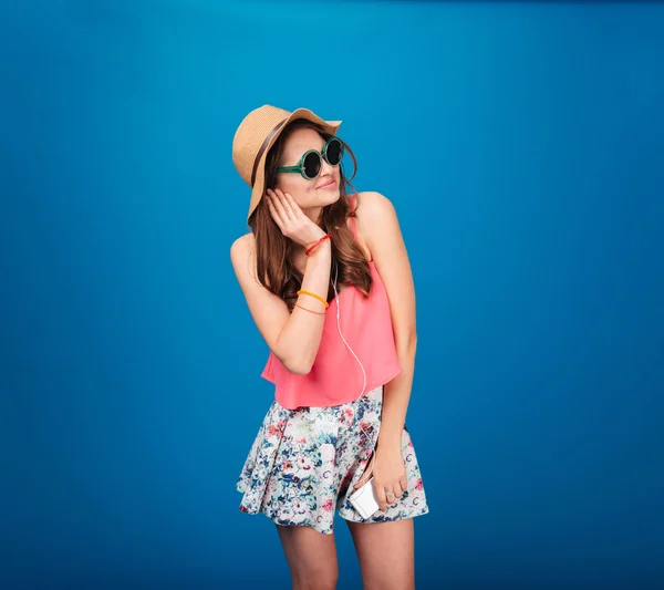 Mujer bonita feliz escuchando música desde el teléfono inteligente usando auriculares —  Fotos de Stock