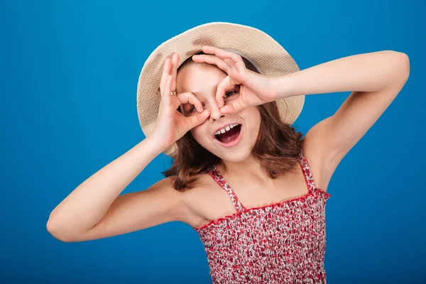 Divertente giocoso bambina in cappello facendo occhiali da mani — Foto Stock