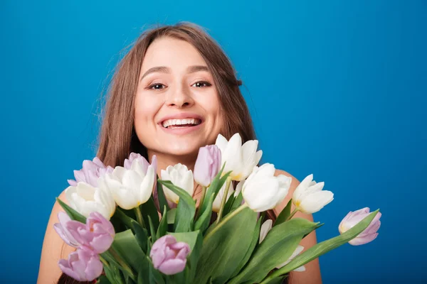 Cheerful beautiful woman smiling and holding bouquet of spring flowers — Stock Photo, Image