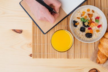 Sağlıklı kahvaltı ve not defterinde masanın üzerine yazma el