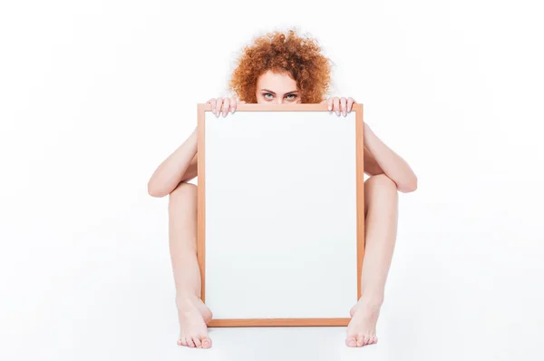 Femme nue assise sur le sol avec tableau blanc — Photo