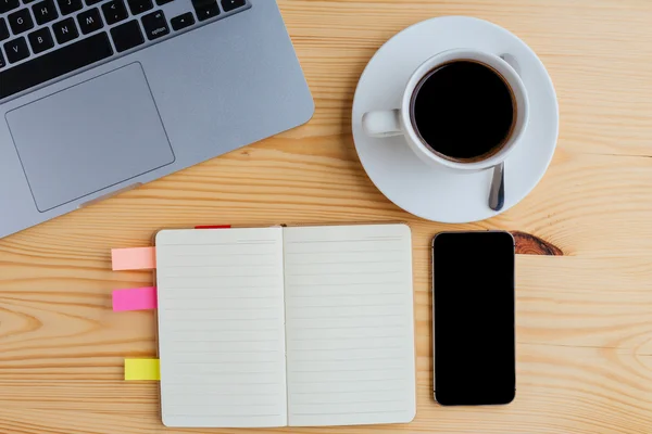 Lugar de trabajo con laptop, bloc de notas, teléfono móvil y taza de café — Foto de Stock