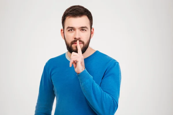 Hombre casual mostrando el dedo sobre los labios —  Fotos de Stock