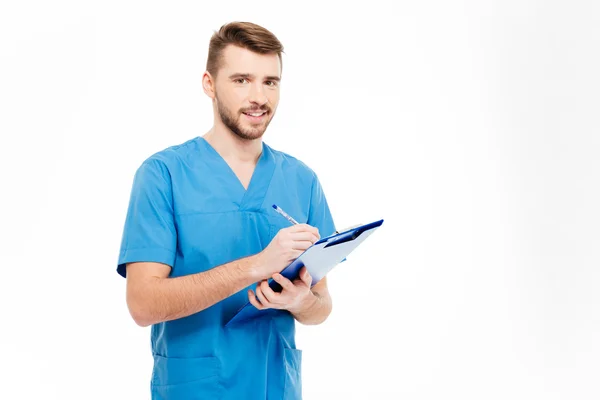 Happy male doctor standing with clipboard — Stock Photo, Image