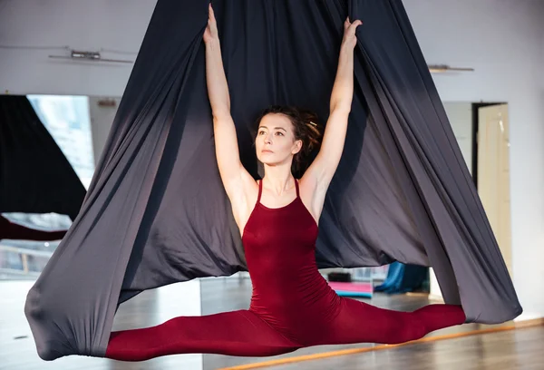 美丽少妇做空中瑜伽在黑色的吊床上 — 图库照片