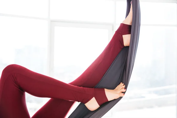Jambes de jeune femme en leggins en utilisant hamac au studio — Photo