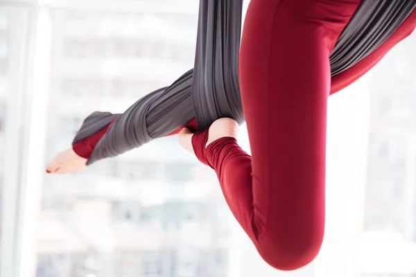 Piernas de mujer joven usando hamaca y haciendo ejercicios aéreos de yoga —  Fotos de Stock