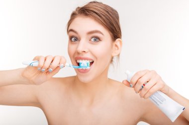 Content lovely woman brushing her teeth with toothpaste and toothbrush