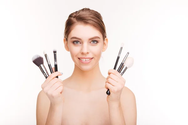 Happy woman holding makeup brushes — Stock Photo, Image