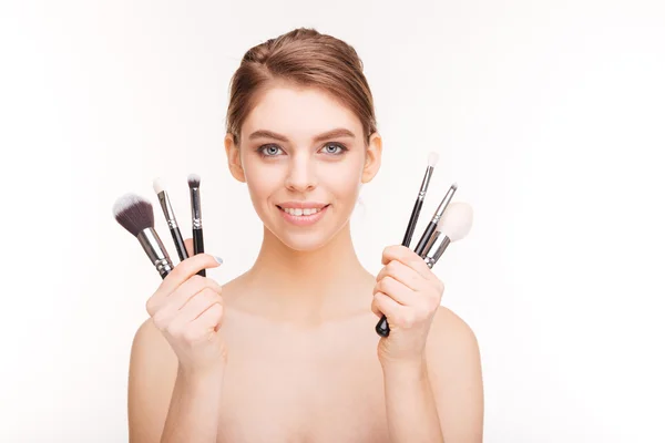 Mulher feliz segurando pincéis de maquiagem — Fotografia de Stock