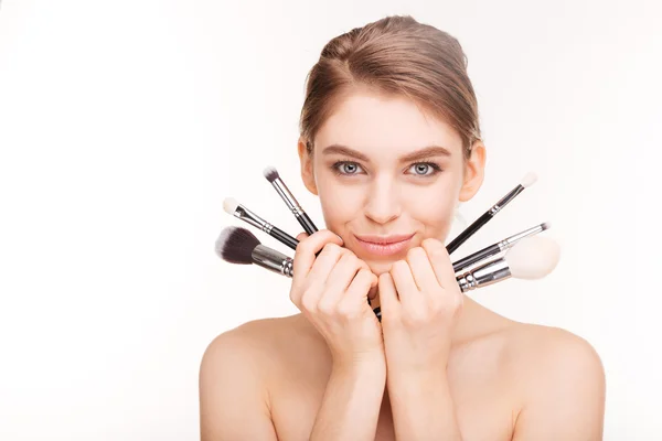 Beauty portrait of pretty smiling young woman with makeup brushes — Stock Photo, Image