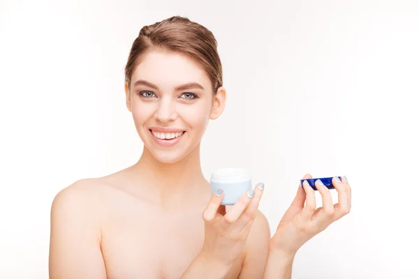 Sorridente donna carina in possesso di crema per il viso — Foto Stock