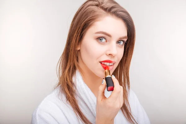 Привлекательная молодая женщина испытывает красную помаду на губах — стоковое фото