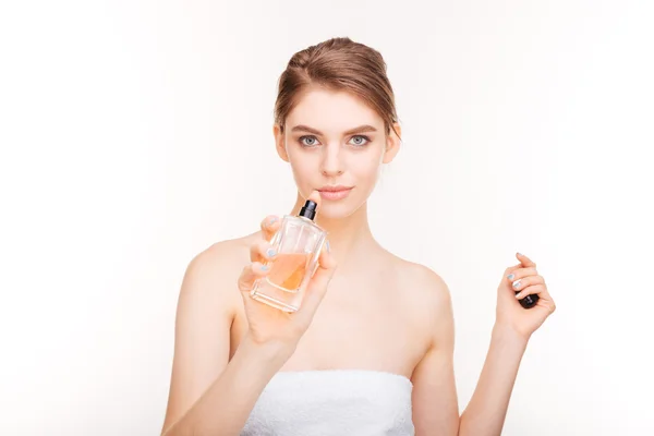 Beautiful young woman with bottle of parfum — Stock Photo, Image