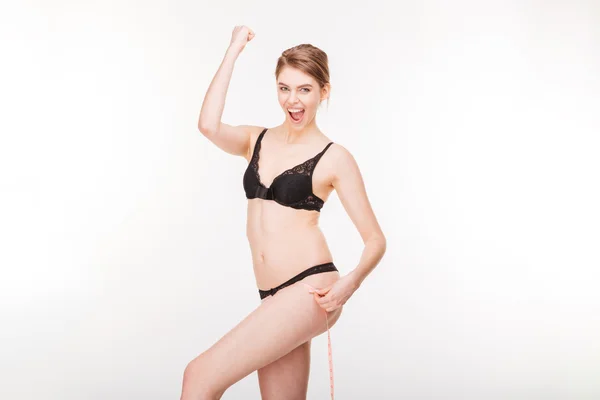 Excited happy young woman celebrating success and measuring her hips — Stock Photo, Image