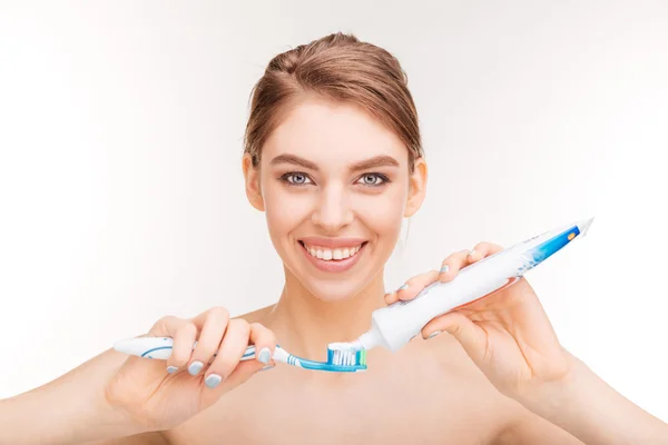 Краса портрет усміхненої молодої жінки з використанням зубної пасти і зубної щітки — стокове фото