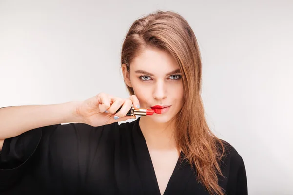 Hermosa mujer mostrando color de lápiz labial en sus labios —  Fotos de Stock