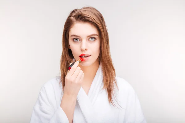 Mulher sensual bonita tentando batom vermelho na metade dos lábios — Fotografia de Stock