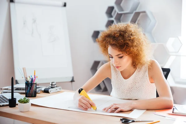 Belle femme photographe cuttung feuille de papier sur son lieu de travail — Photo