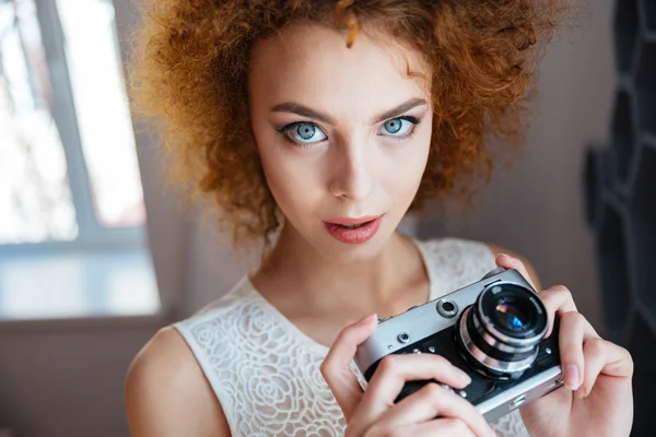 Vackra redhead lockigt ung kvinna fotograf med vintage kamera — Stockfoto