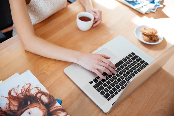 Table of woman photographer working with laptop and drinking coffee — Stock Photo, Image