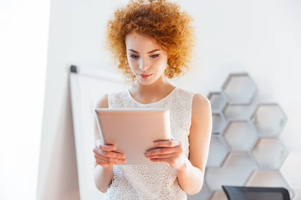 Mujer de negocios seria usando tableta en la oficina —  Fotos de Stock