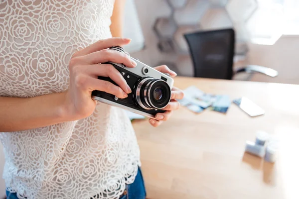 Stary aparat przechowywany przez młoda kobieta fotograf w biurze — Zdjęcie stockowe