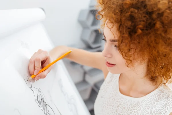 Hermosa mujer diseñadora de moda haciendo bocetos en el rotafolio — Foto de Stock