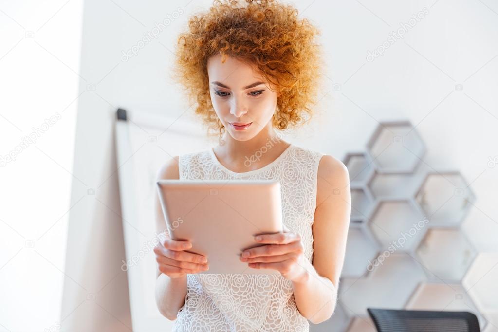 Serious business woman using tablet in office