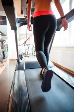 Spor salonunda koşu bandında koşan çekici bir sporcu.