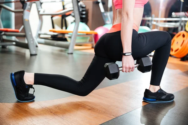 Woman athlete doing squats with dumbbells in gym — Stock Photo, Image