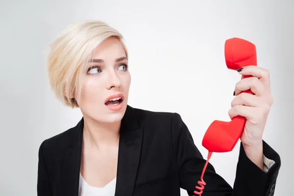 Scared businesswoman holding phone tube — Stock Photo, Image