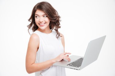 Dizüstü bilgisayar kullanan ve uzağa bakarak gülümseyen kadın