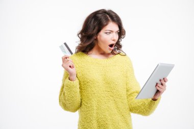 Kredi kartı ve tablet bilgisayar tutan şok kadın