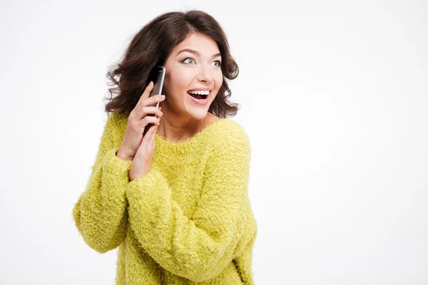 Здивована жінка, що прикриває мікрофон під час розмови по телефону — стокове фото