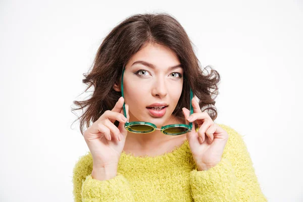 Belle femme tenant des lunettes de soleil et regardant la caméra — Photo