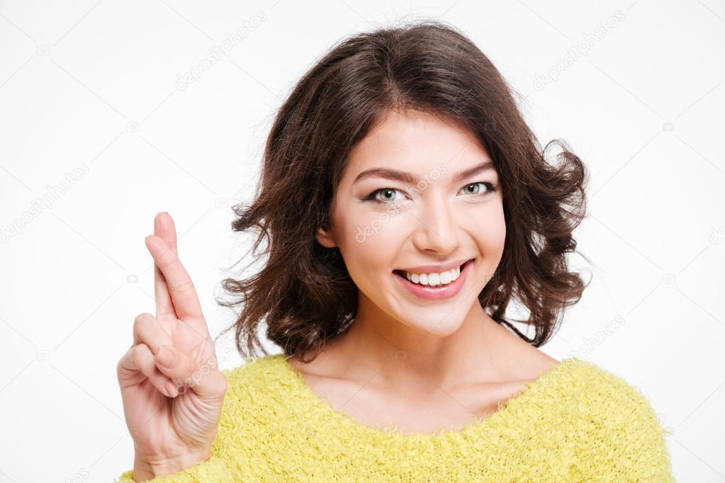 Smiling woman standing with crossed fingers 