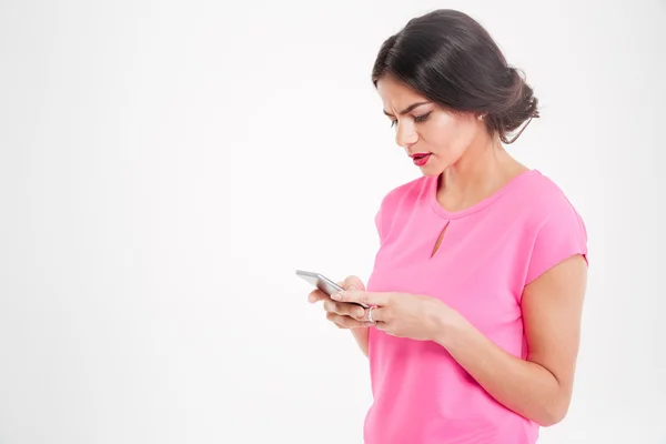 Ongelukkig fronsend jonge vrouw met behulp van smartphone — Stockfoto