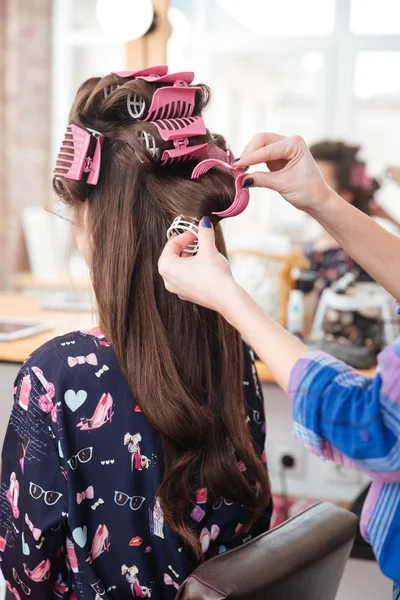 Friseur entfernt Lockenwickler von langen Haaren der Frau — Stockfoto