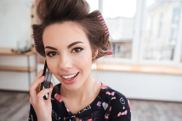 Vidám nő beszél a mobiltelefon hajcsavarók — Stock Fotó