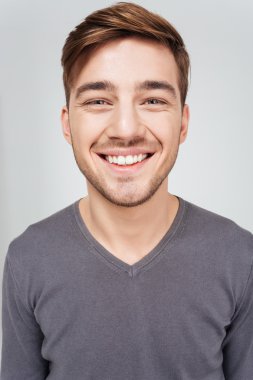 Neşeli yakışıklı genç adam kameraya bakarak closeup 