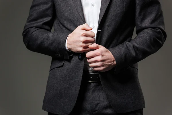 Händerna på stilig affärsman i svart kostym och vit skjorta — Stockfoto