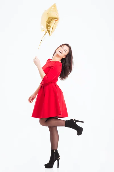Leende kvinna i röd klänning anläggning ballong — Stockfoto