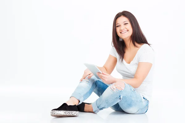 Mulher feliz sentado no chão e usando computador tablet — Fotografia de Stock