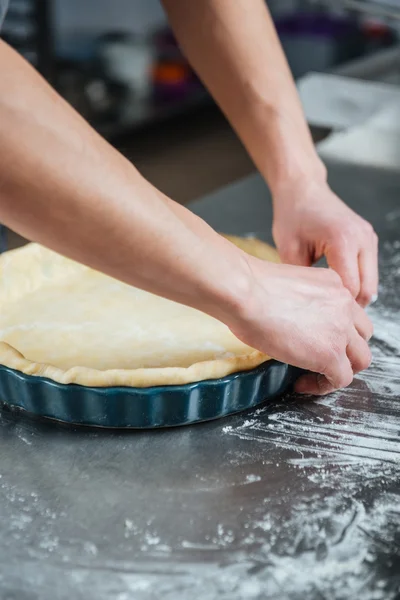 Αρσενικό χέρια μαγείρεμα πίτα στο ταψί — Φωτογραφία Αρχείου